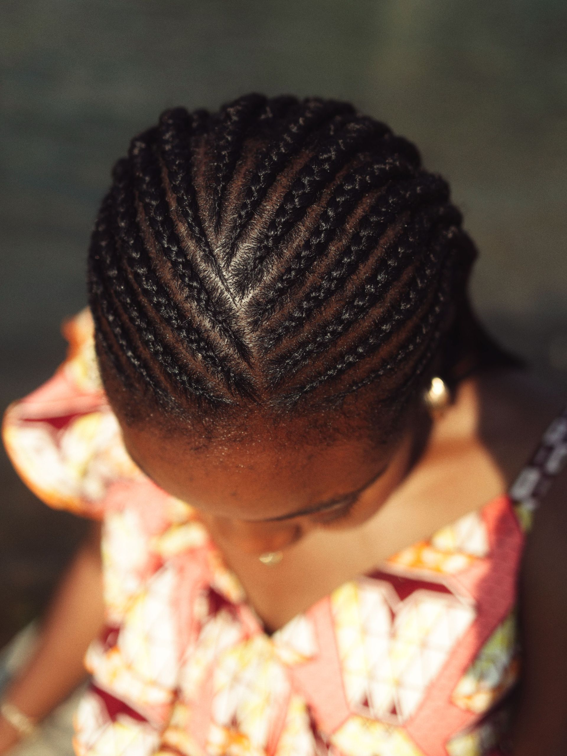 Detailed top view of intricate braided hairstyle on woman's head, showcasing traditional beauty.