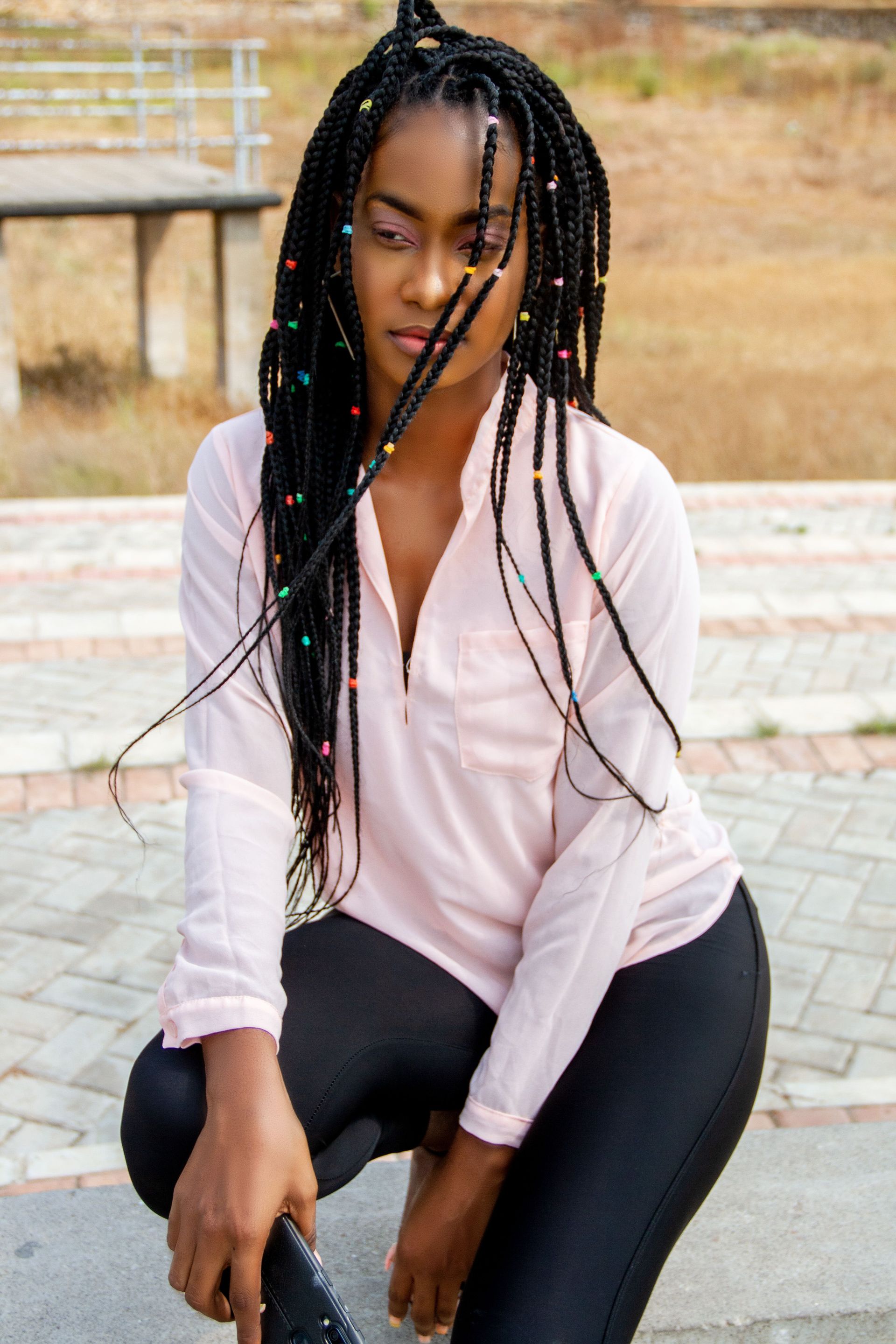Young thoughtful African American female in casual outfit with trendy hairstyle looking away