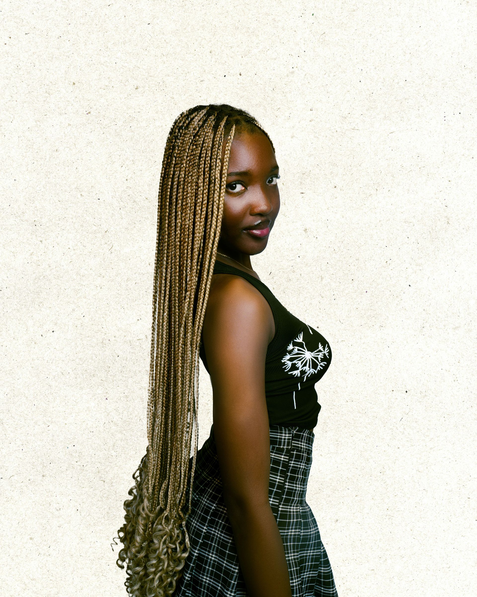 Stylish woman with long braided hair in a modern fashion pose.
