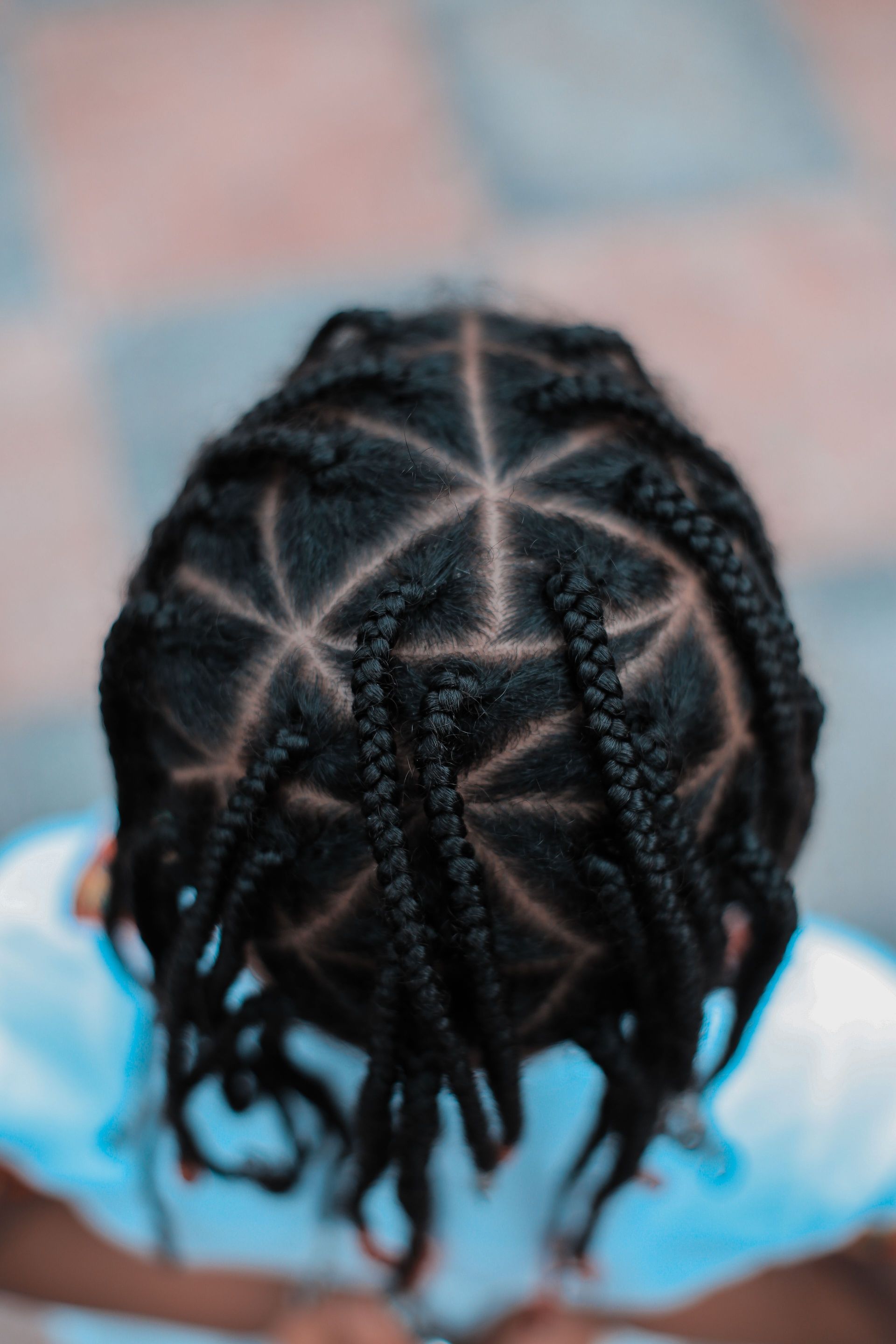 Close-up top view of intricate braided hairstyle on a child, showcasing a unique pattern.
